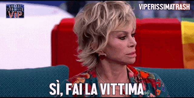 a woman sitting on a couch with the words si fai la vittima written on her face