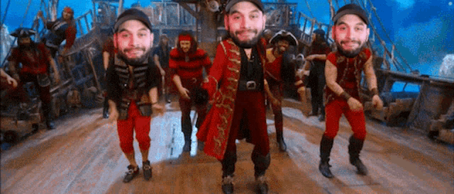 a group of men in pirate costumes are dancing on a wooden floor