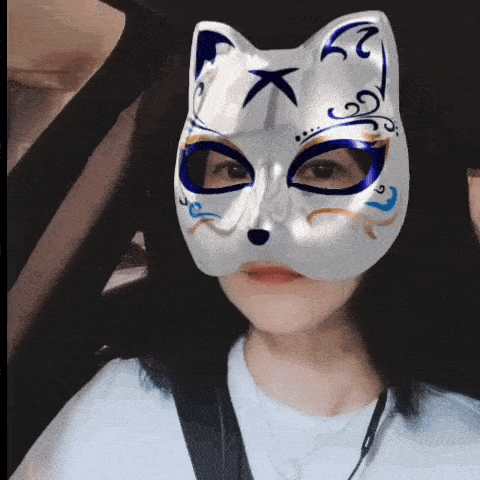 a woman wearing a white cat mask with a blue eye