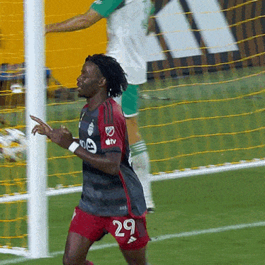 a soccer player with the number 29 on his shorts celebrates a goal