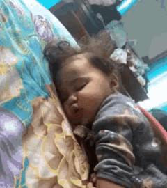 a baby is sleeping on a bed with a floral blanket