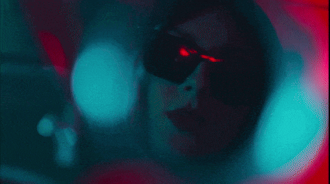 a blurry picture of a woman 's face with a blue light behind her