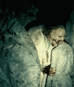 a man with blood on his face is holding a woman