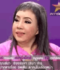 a woman in a pink shirt is talking on a television show .
