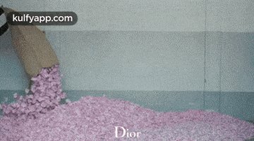 a person is putting pink flowers in a wicker basket .
