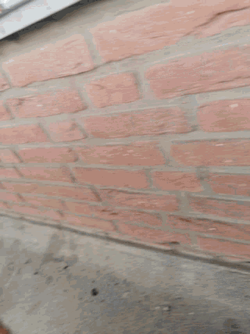 a brick wall with a few pieces of trash on it