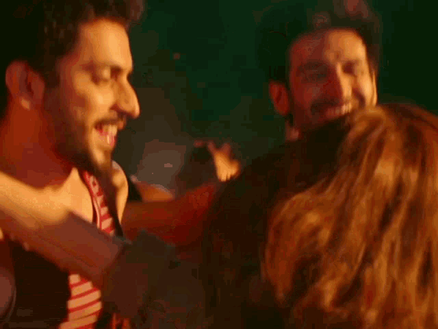 a group of people are dancing and laughing in a room .