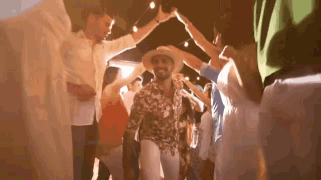 a man in a cowboy hat is dancing in a crowd