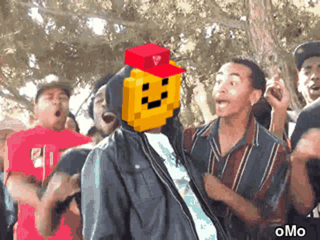 a man with a pixelated face on his head is surrounded by people and the word omo is on the bottom right