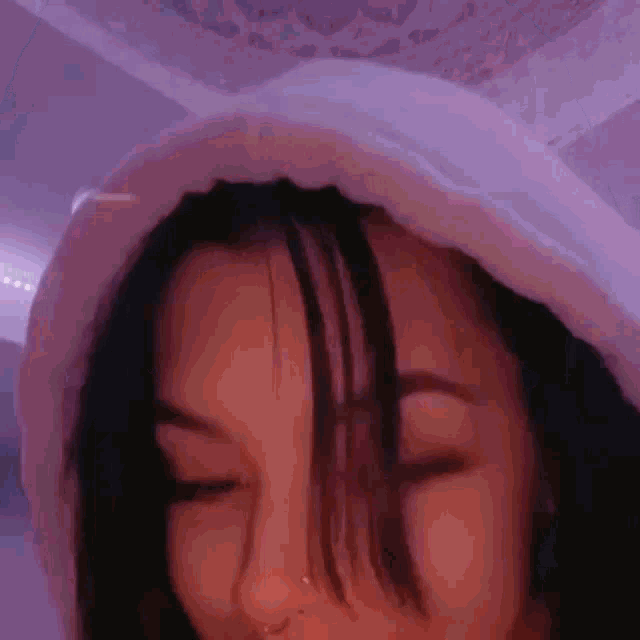a close up of a girl wearing a hoodie and a nose ring .