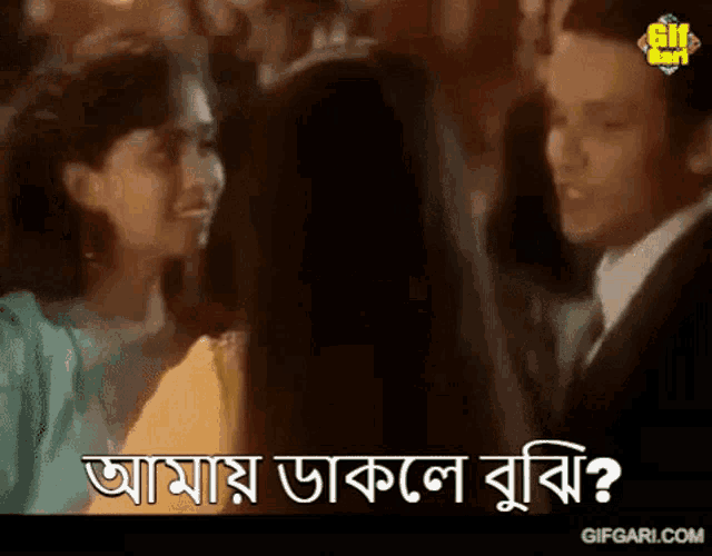 a man in a suit is talking to a woman in a yellow dress while another woman looks on .