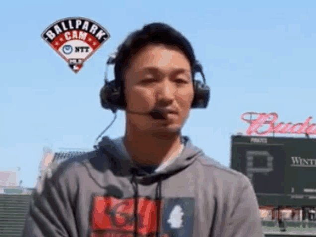 a man wearing headphones and a shirt that says ball park cam