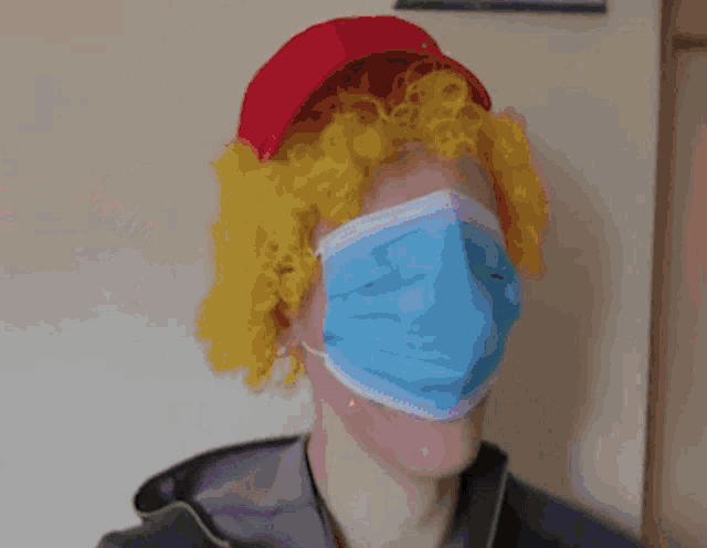 a man wearing a red hat and a blue mask looks at another man
