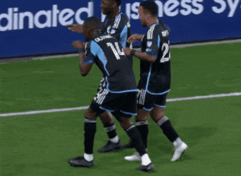 a group of soccer players are celebrating a goal in front of a sign that says connected business