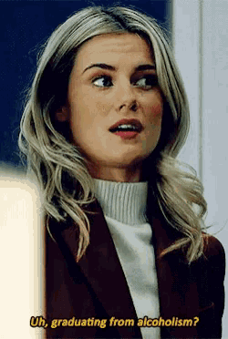 a woman in a brown jacket and white turtleneck is talking about alcoholism