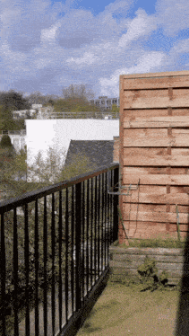 a balcony with a wooden fence and a metal railing