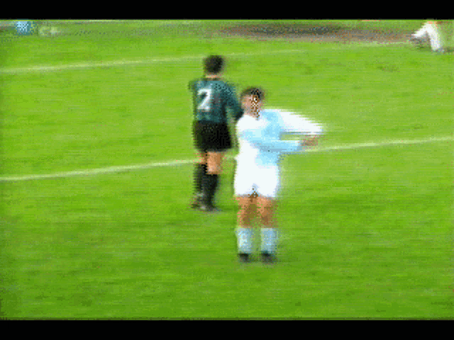 a blurry picture of a soccer game with a player wearing a white shirt with the letter a on it
