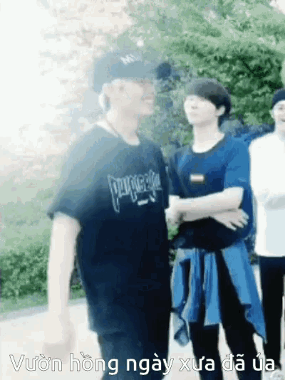 a man wearing a t-shirt that says pleasures stands next to another man