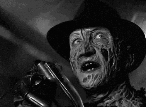 a black and white photo of freddy krueger from nightmare on elm street holding a knife .