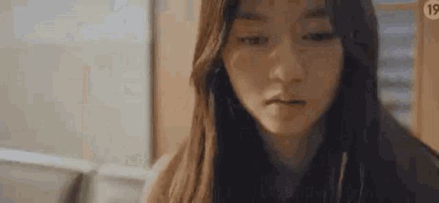 a close up of a woman 's face with long hair looking at the camera .