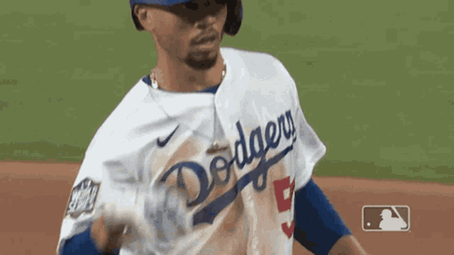 a dodgers baseball player holds a can of soda