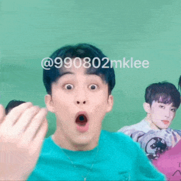 a man in a blue shirt is making a funny face with his mouth wide open .