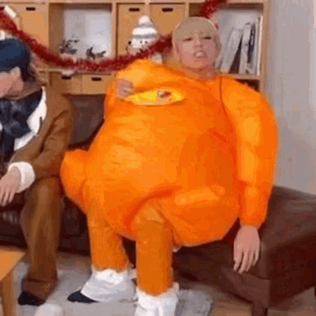 a man in a turkey costume is sitting on a couch .