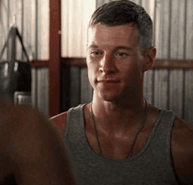 a man in a tank top looks at another man