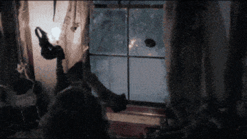 a person standing in front of a window with a broken glass pane