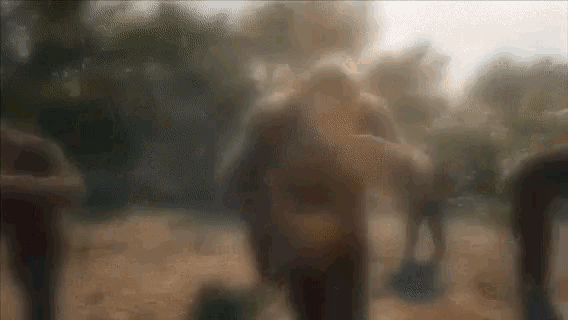 a blurry picture of a group of people standing on a dirt field
