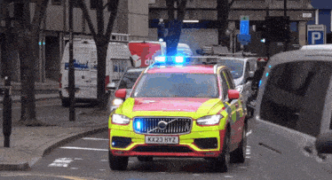 a red and yellow volvo with a license plate kx23 hyz