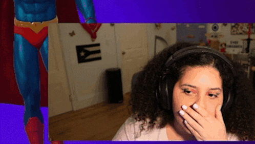 a woman wearing headphones is covering her mouth in front of a superhero