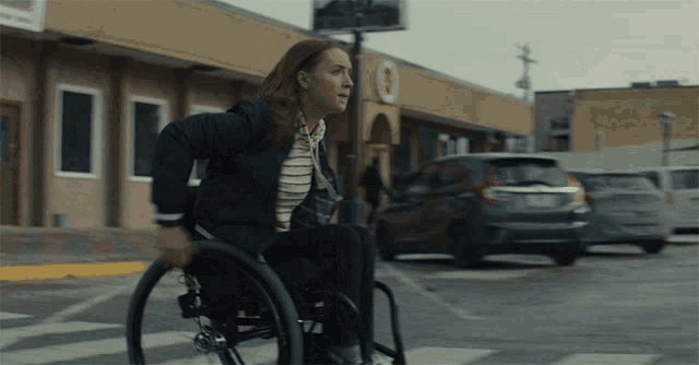 a woman in a wheelchair is crossing the street in front of a target store
