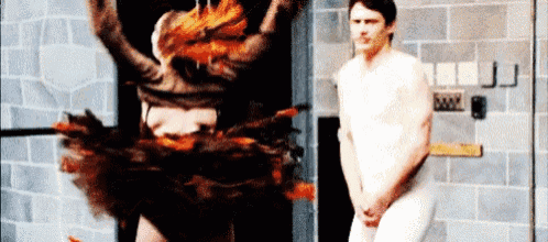 a naked man is standing in front of a naked woman in a costume .