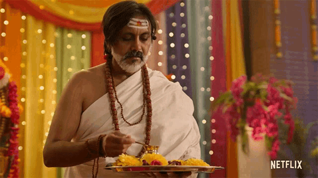 a man in a white robe is holding a tray with netflix written on it