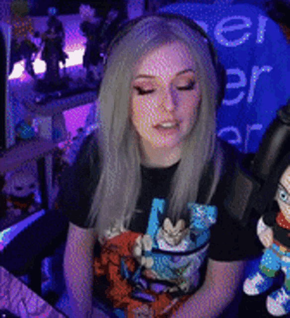 a woman wearing headphones and a dragon ball z shirt is sitting in front of a microphone
