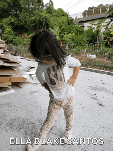 a little girl wearing sunglasses and a shirt that says " ella blake santos " on it