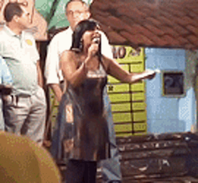 a woman is singing into a microphone in front of a sign that says 10 on it