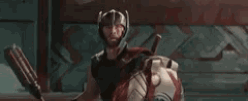 a man in a helmet is standing in front of a wall and says yes .