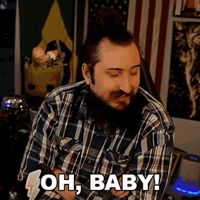 a man with a beard in a plaid shirt is saying oh baby