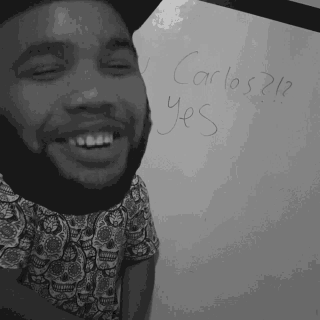 a man is smiling in front of a white board that says yes