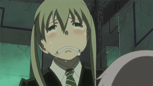 a girl in a suit and tie is crying with her eyes closed