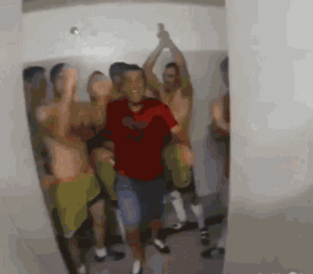 a man in a red shirt is surrounded by a group of men