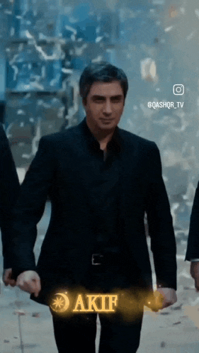 a man in a suit is walking down a street holding hands with another man .