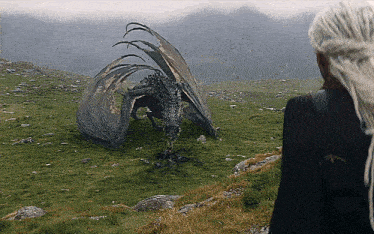 a woman standing next to a dragon in a field with mountains in the background