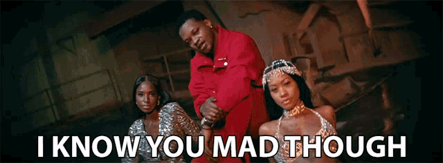 a man in a red jacket is standing next to two women with the words " i know you mad though " below them