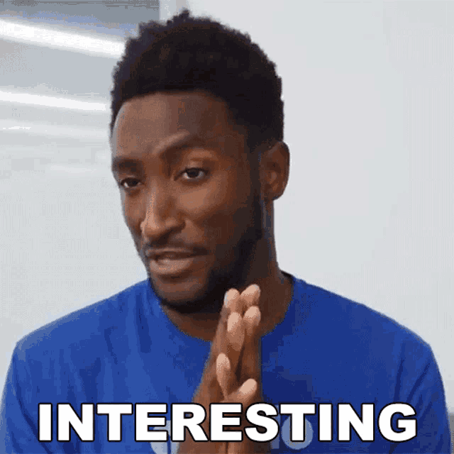 a man in a blue shirt says interesting with his hands together
