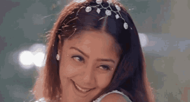 a close up of a woman wearing a headband with pearls on it