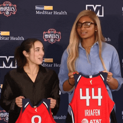 a woman holding a jersey that says 44 on it