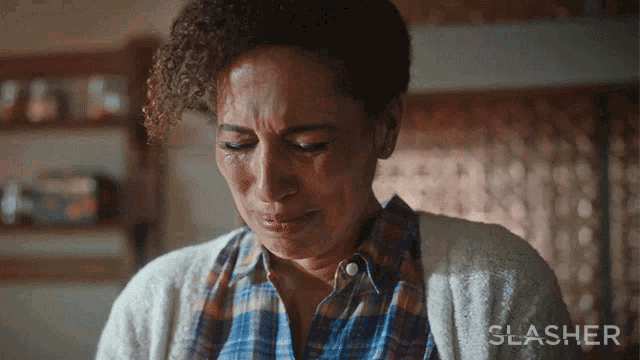 a woman is crying in front of a sign that says ' slasher ' on it